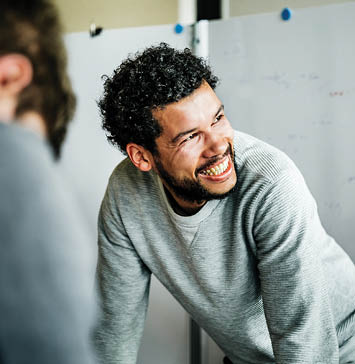 Man looking off camera while smiling in casual clothes