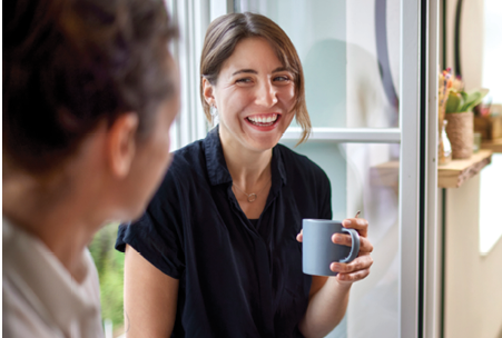 Co-workers smiling having coffee