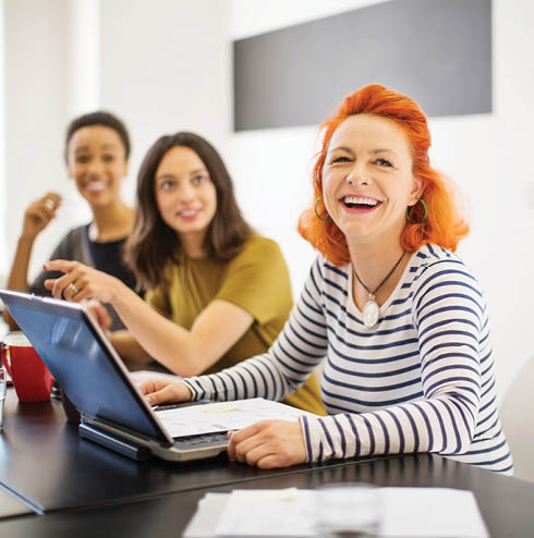 office workers in a meeting smiling and laughing